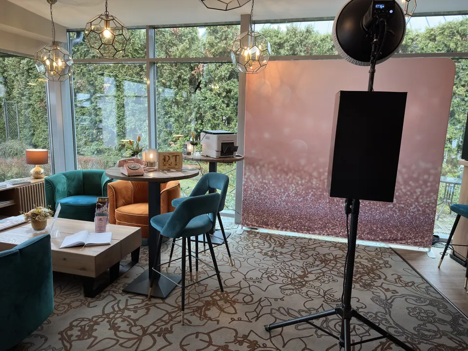 Klasszikus szelfigép rózsaarany csillogó háttérfallal, villanóval és nyomtatóval egy kávézó lounge-terében